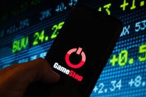 Logo GameStop sul cellulare e sfondo di trading